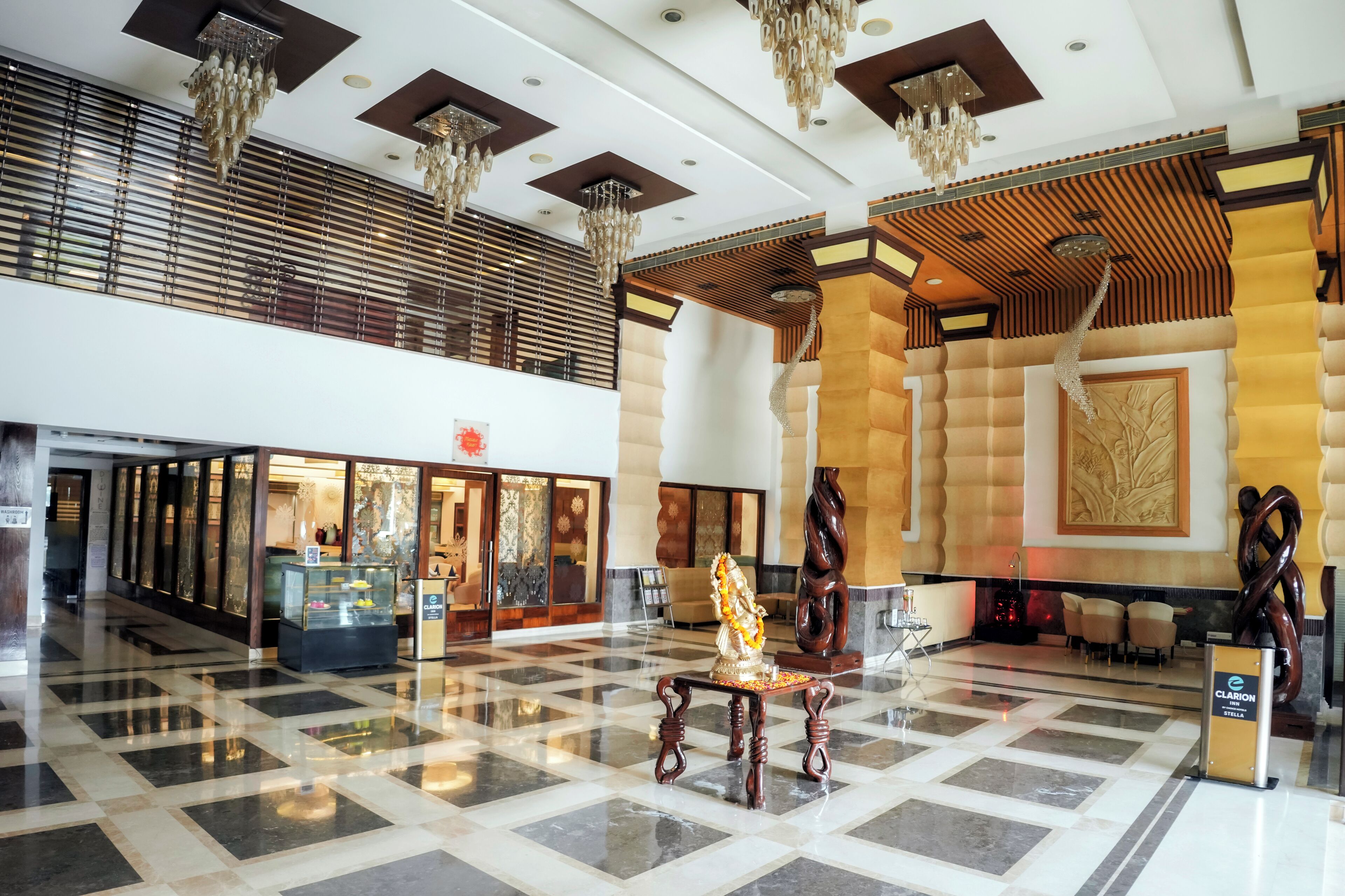 A lobby with a checkered floor, a reception desk, and a statue.