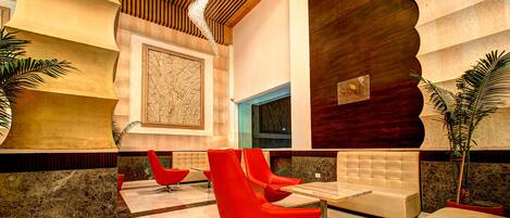 A lobby with red chairs, a wooden ceiling, and a large wall mural.