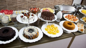 Una mesa de buffet con diversos postres y alimentos.