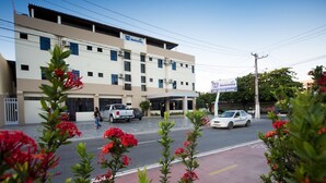 Un edifici de diverses plantes amb un cartell de 'Residencia' i una zona d'aparcament al davant.