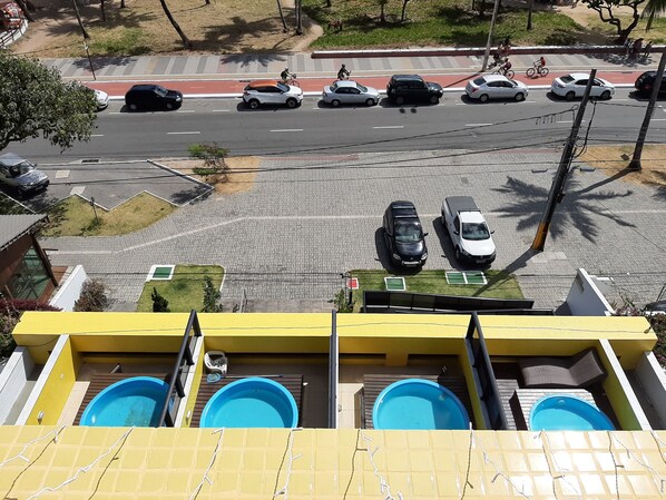 Zona residencial con vista a la calle, incluyendo automóviles estacionados y un paso de peatones.