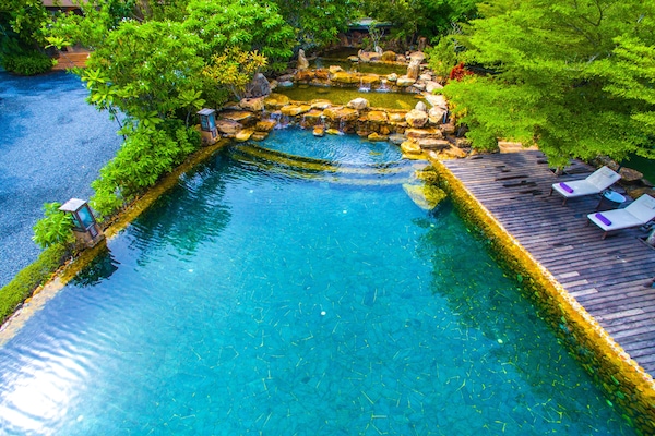 Una piscina al aire libre, sillones reclinables de piscina
