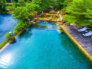 A clear blue pool surrounded by lush greenery, with a wooden deck and lounge chairs. - Parama Koh Chang (Ko Chang)