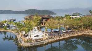 Een resort met een zwembad, een loungeruimte en boten afgemeerd aan het water.