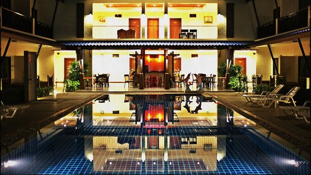Un hotel con piscina, zona de recepción y comedor.