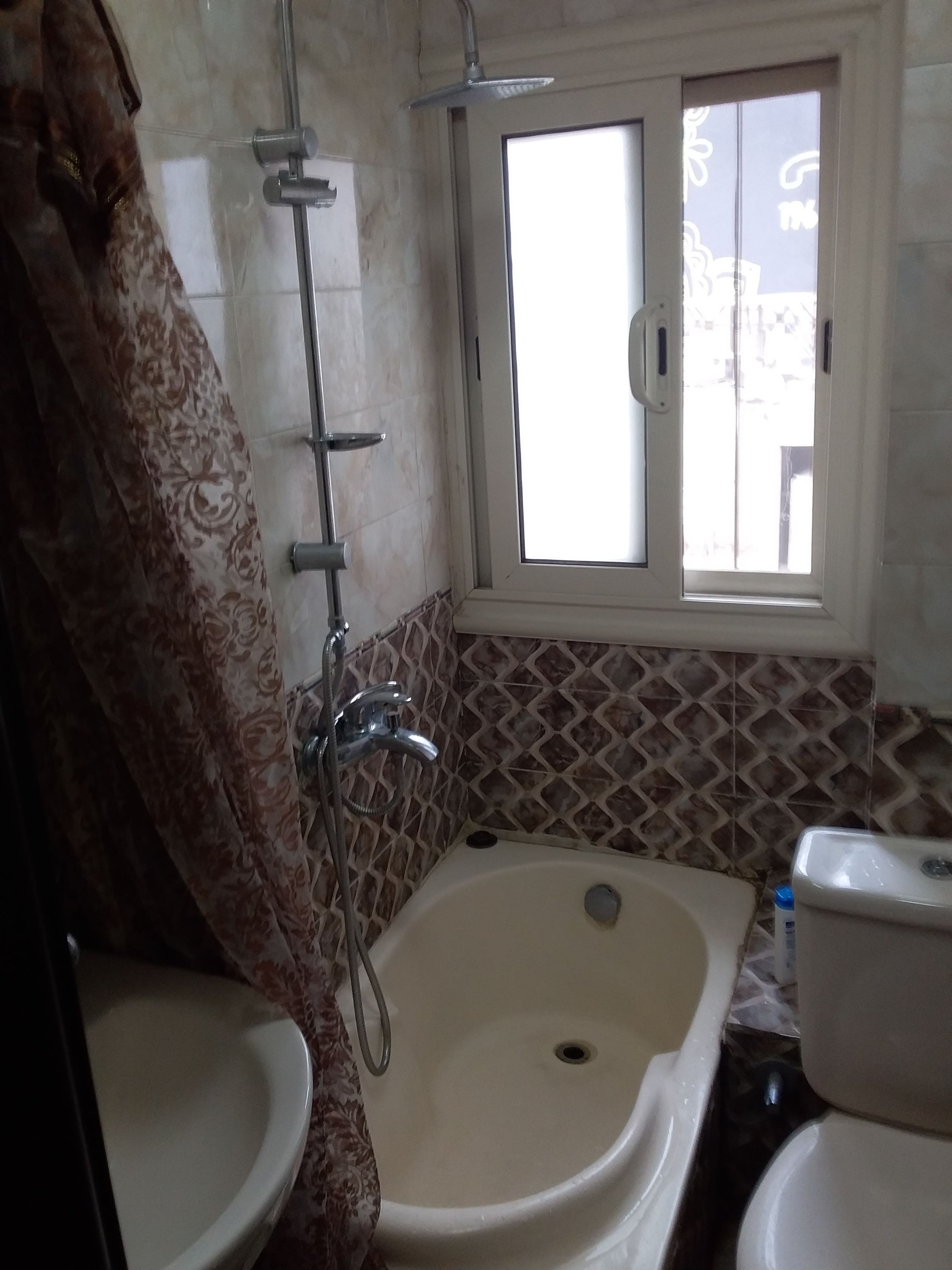 A bathroom with a shower, a toilet, and a sink.