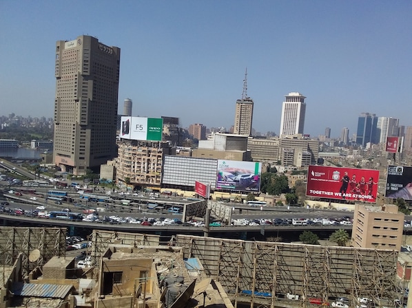 Un paisaje urbano con rascacielos, una autopista con tráfico intenso y vallas publicitarias.