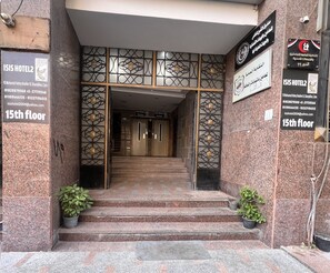 The entrance to ISIS Hotel2 on the 15th floor, with a sign indicating the hotel's location at 10 Mohamed Helmy Ibrahim St. Shamlon, Cairo.