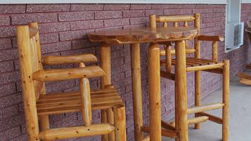 A wooden outdoor seating area with a metal sign above.