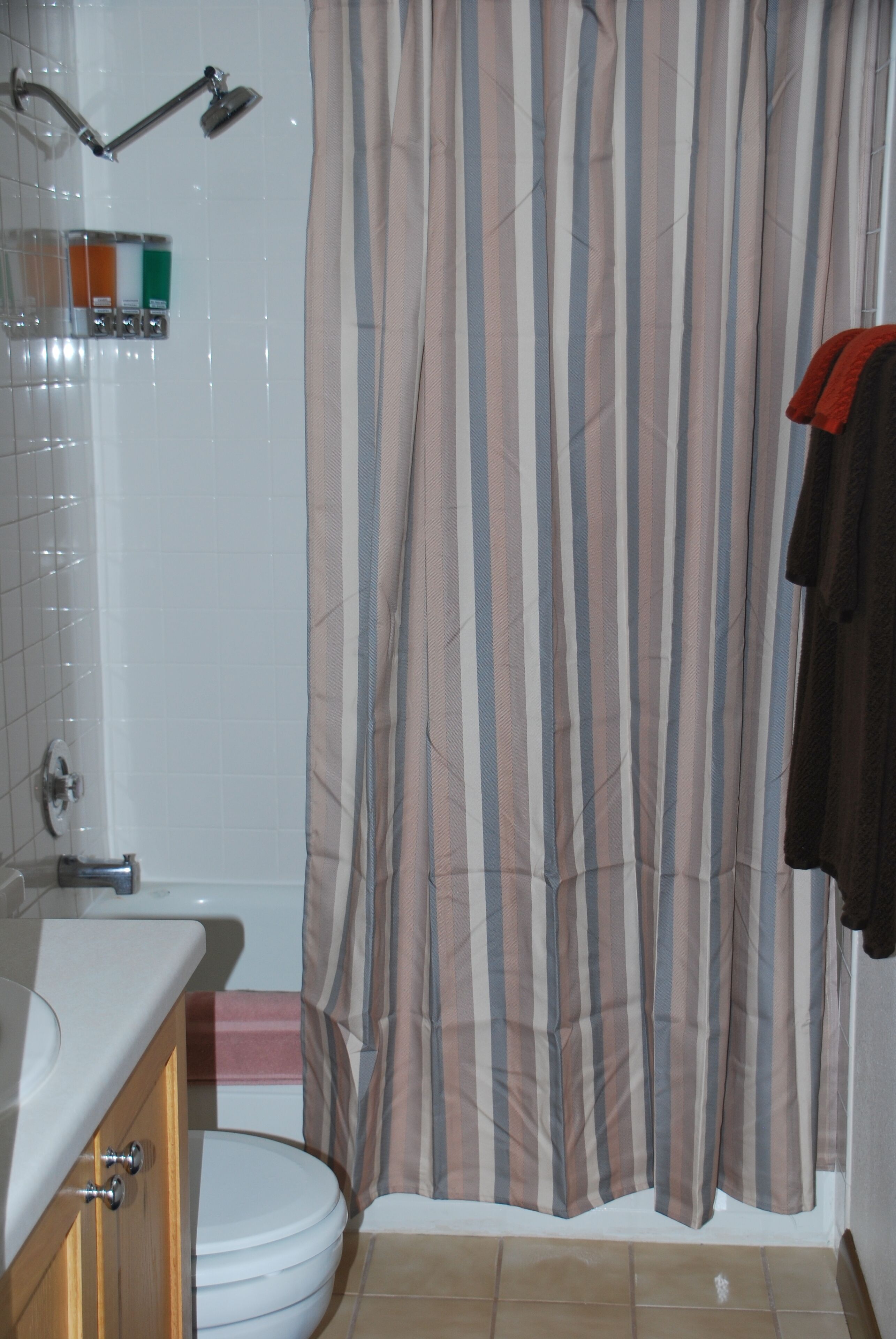 A bathroom with a shower, toilet, and sink.