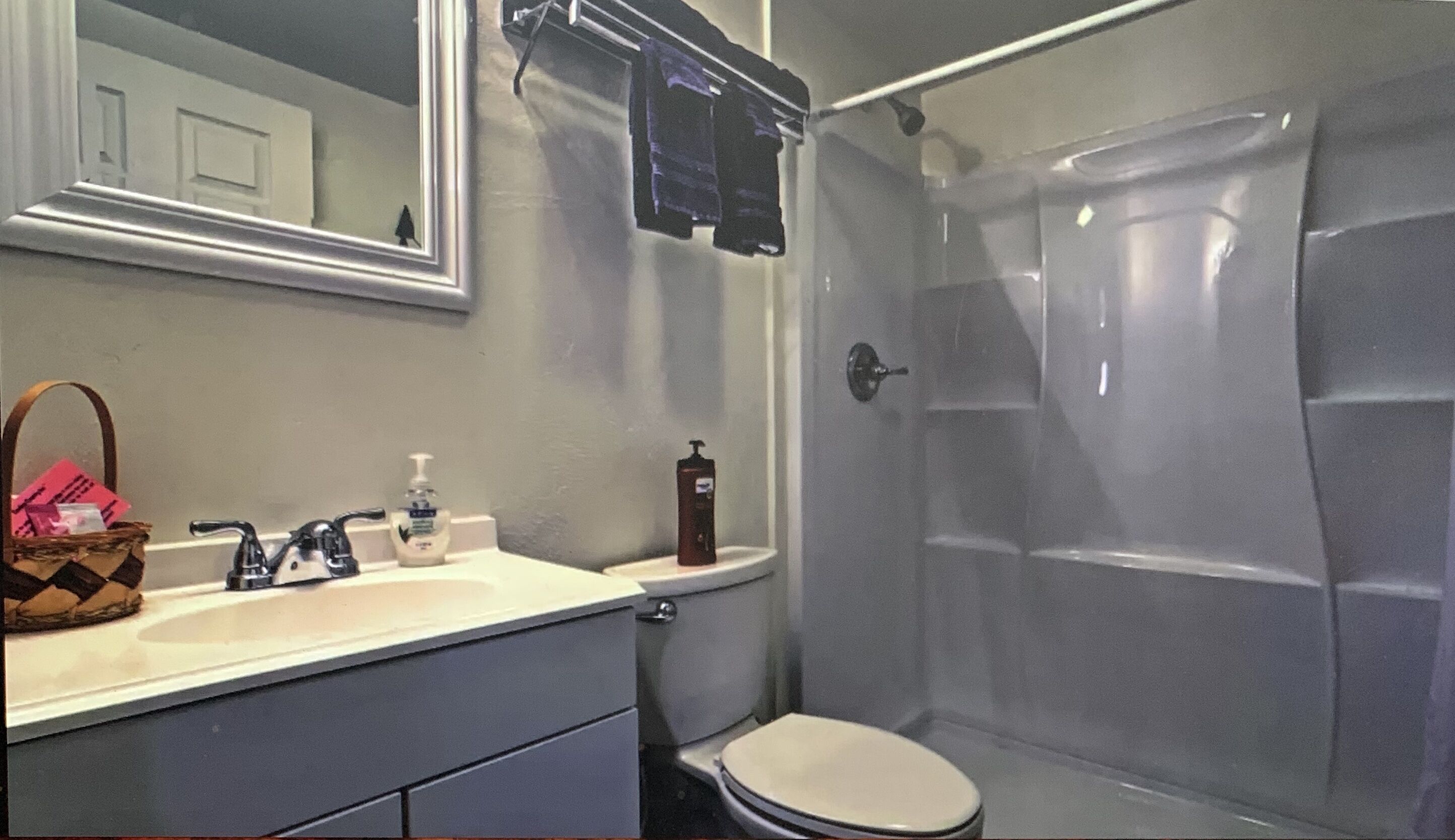 Un baño con lavabo, espejo, inodoro y ducha.