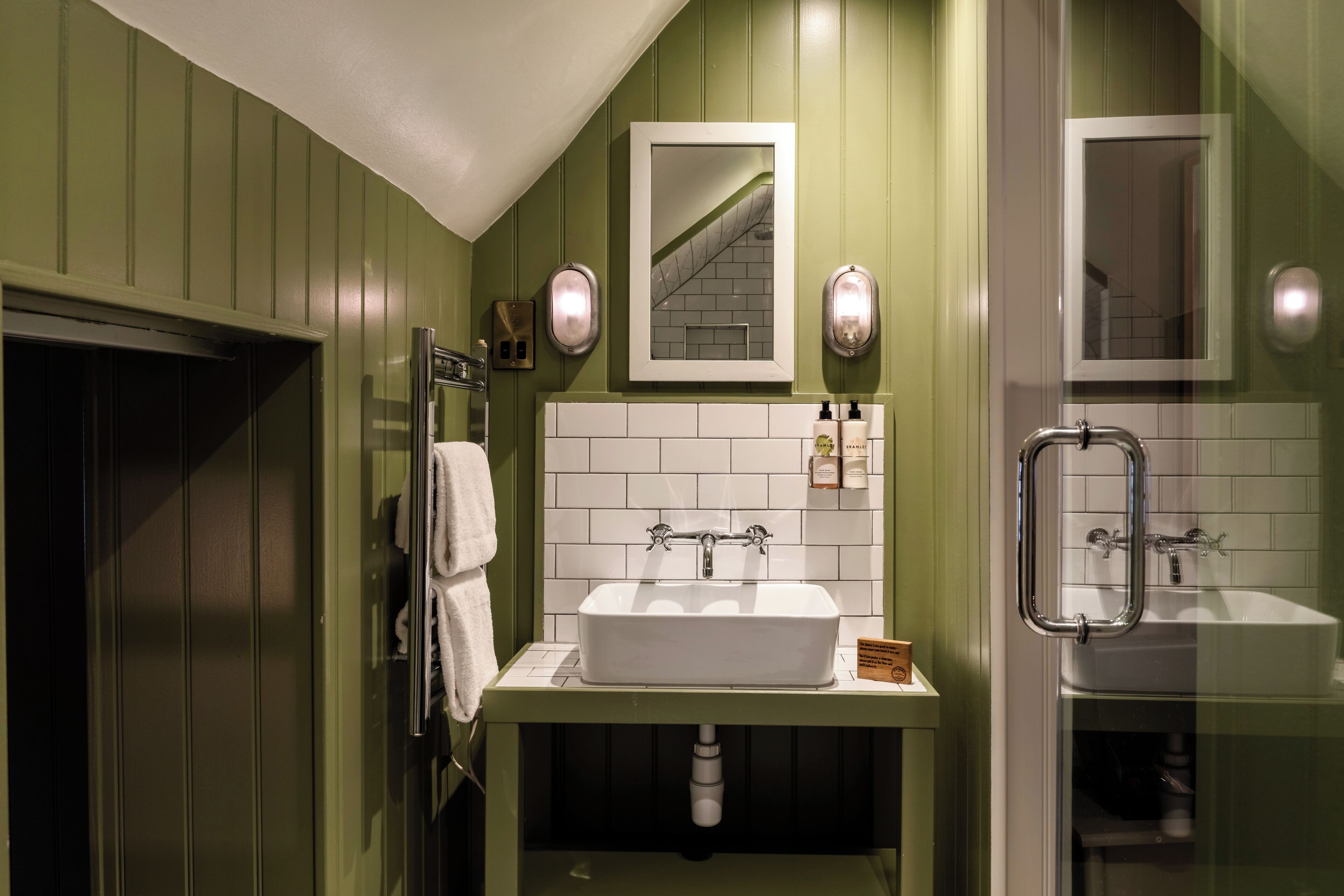 A bathroom with a white sink, a mirror, and a shower area.