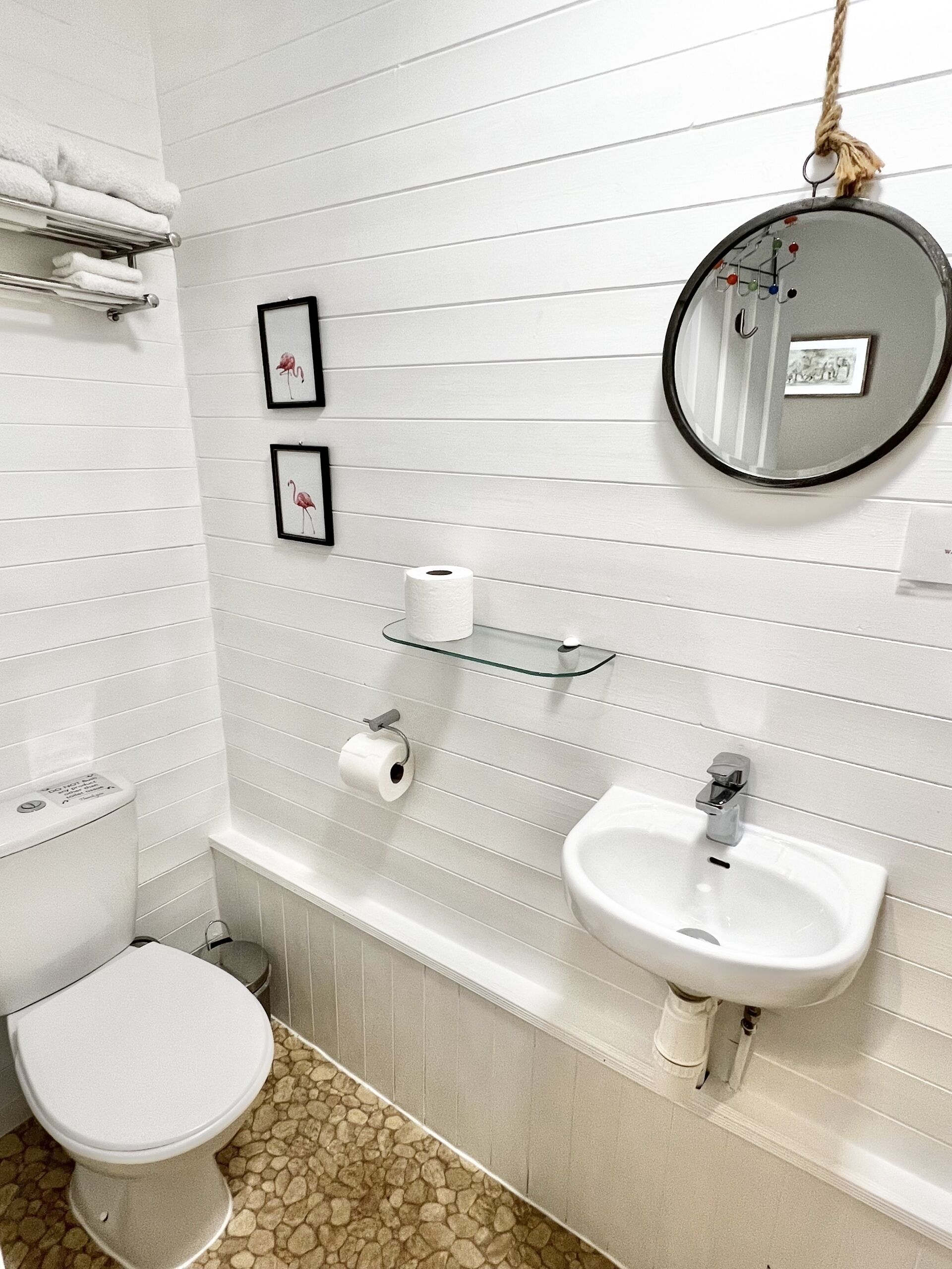 A bathroom with a toilet, sink, and towel rack.