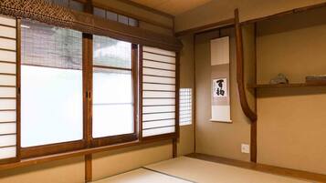 Ett traditionellt japanskt rum med tatamimattor på golvet, shojiskärmar och en skjutdörr.