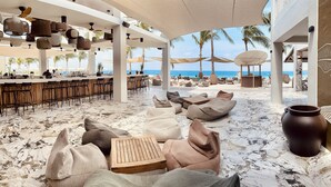 Een strandlounge met zitplaatsen en een bar, met uitzicht op zee.