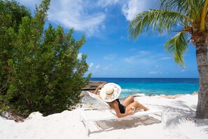 On the beach, white sand, sun loungers, beach towels