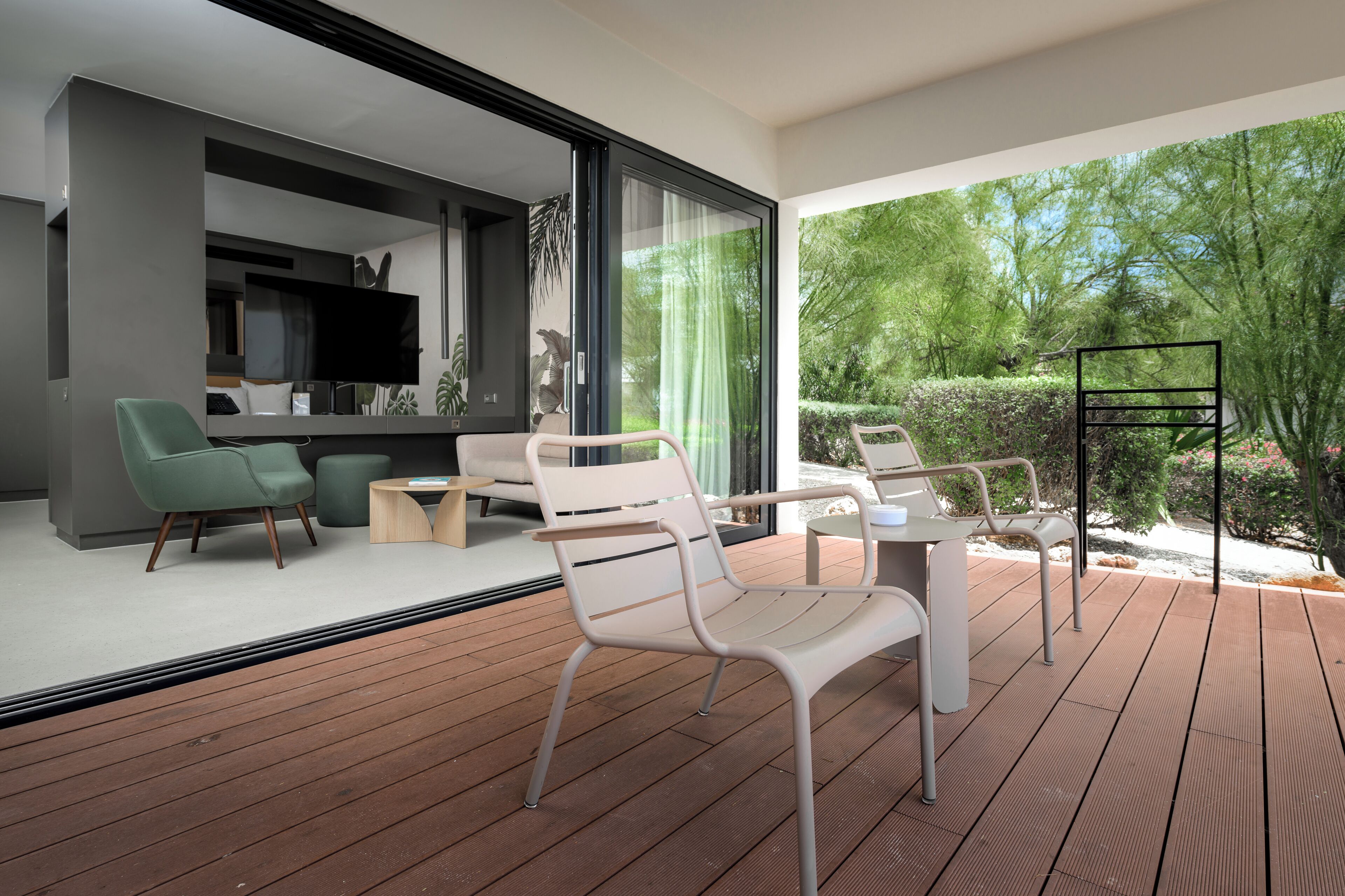 A modern living room with a large window, a dining area with a table and chairs, and a wooden deck.