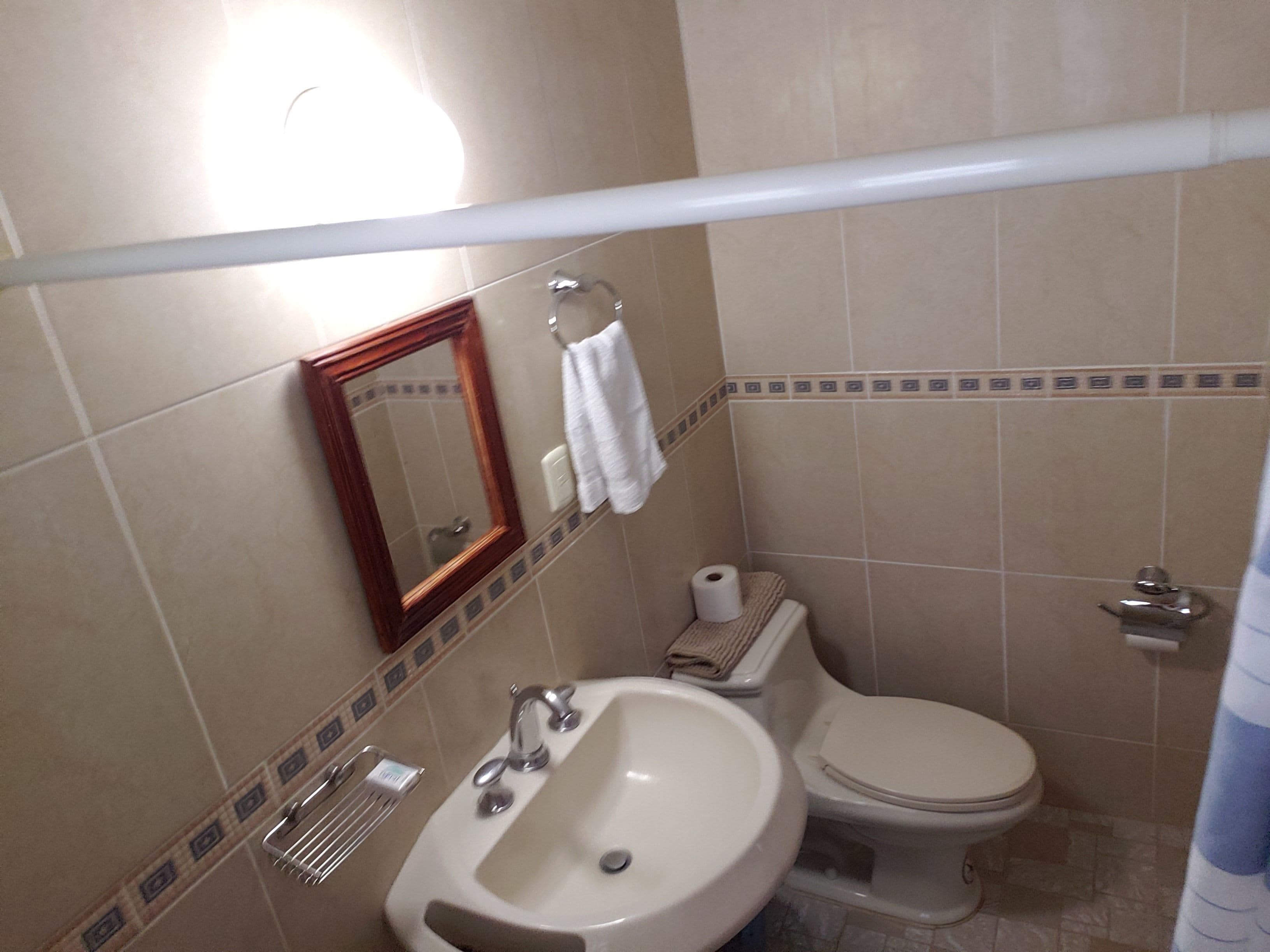 Un baño con lavabo, inodoro y espejo.