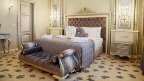 A luxurious bedroom with a tufted headboard, a plush sofa, and ornate wall sconces. - Cassiel Hotel (Ankara)