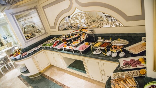 A buffet with various food items and a decorative mirror above it. - Cassiel Hotel (Ankara)