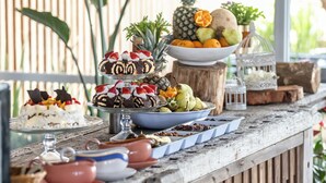 Una mesa de madera rústica con diversos alimentos y una pieza decorativa central.