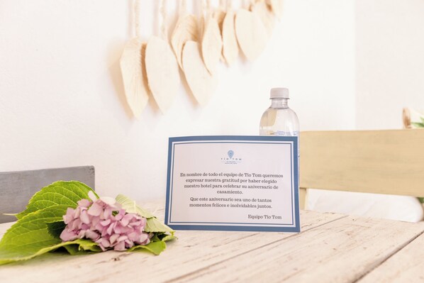Tarjeta de mensaje en un marco sobre una mesa de madera, con una botella y flores.