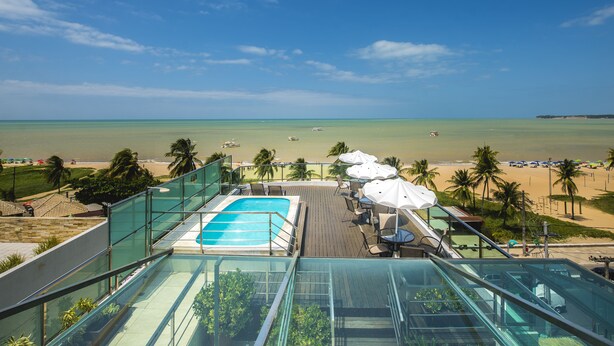 A rooftop pool with a clear view of the beach and ocean.