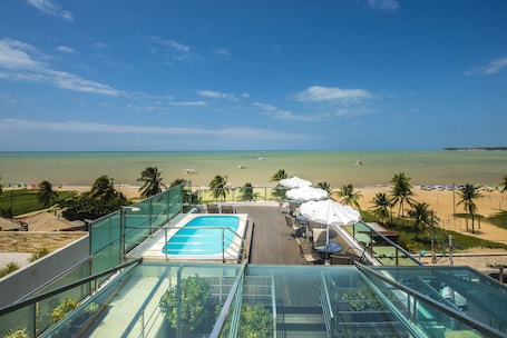 Una piscina al aire libre, sillones reclinables de piscina