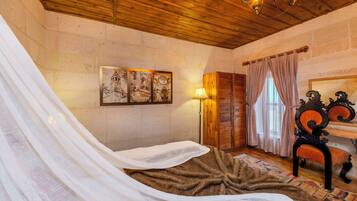 Quarto com uma cama, um guarda-roupa de madeira, uma luminária e um quadro na parede.