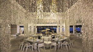 Un restaurant doté d’un plafond au design original, de nombreuses tables et de chaises.