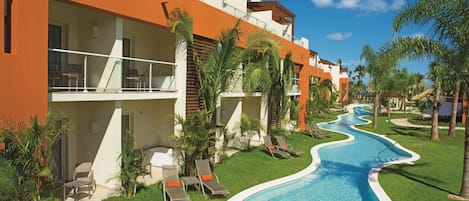 A hotel with a swimming pool, outdoor seating, and palm trees.