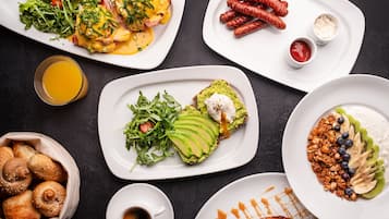 A variety of breakfast dishes including eggs, sausages, and avocado toast.