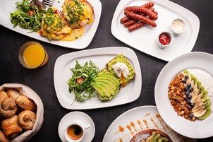 Un'ampia scelta di piatti per la colazione, tra cui uova, salsiccia e toast all'avocado.