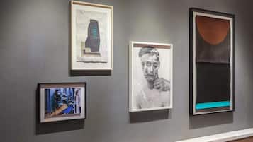 Een galerij met ingelijste kunstwerken aan een muur.