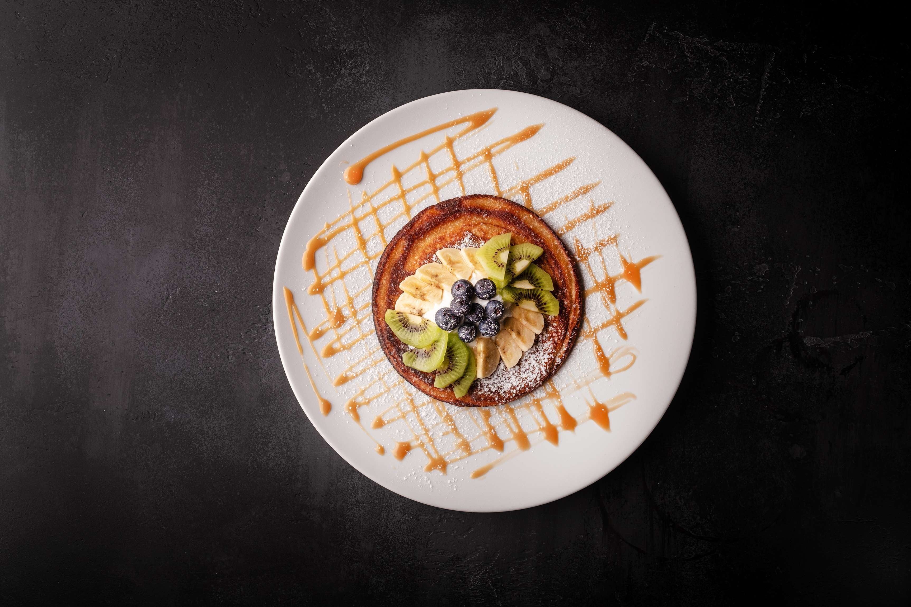 A dessert on a white plate with a dark background.