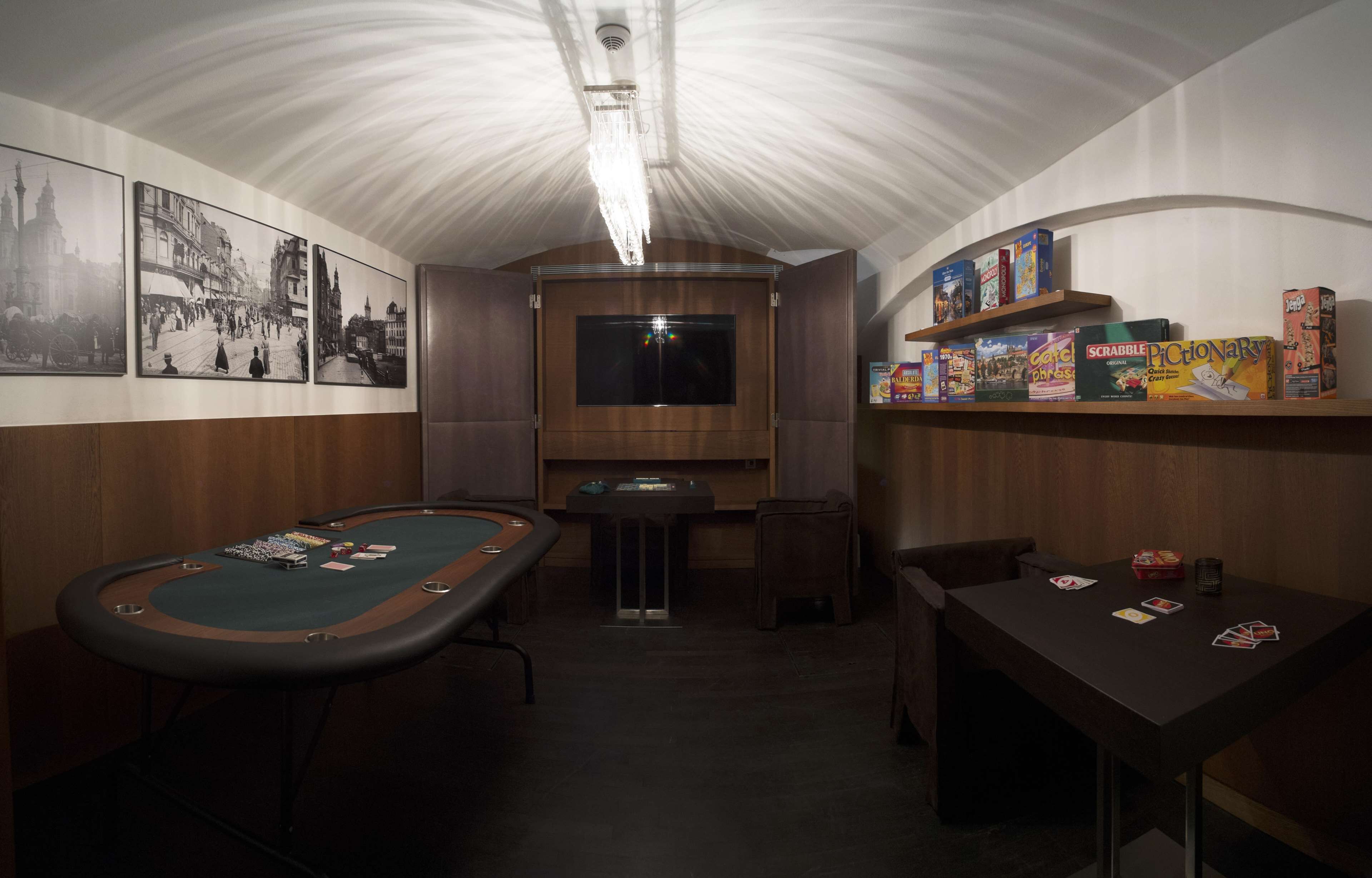 Una habitación con mesa de billar, televisor y estantes llenos de juegos de mesa.