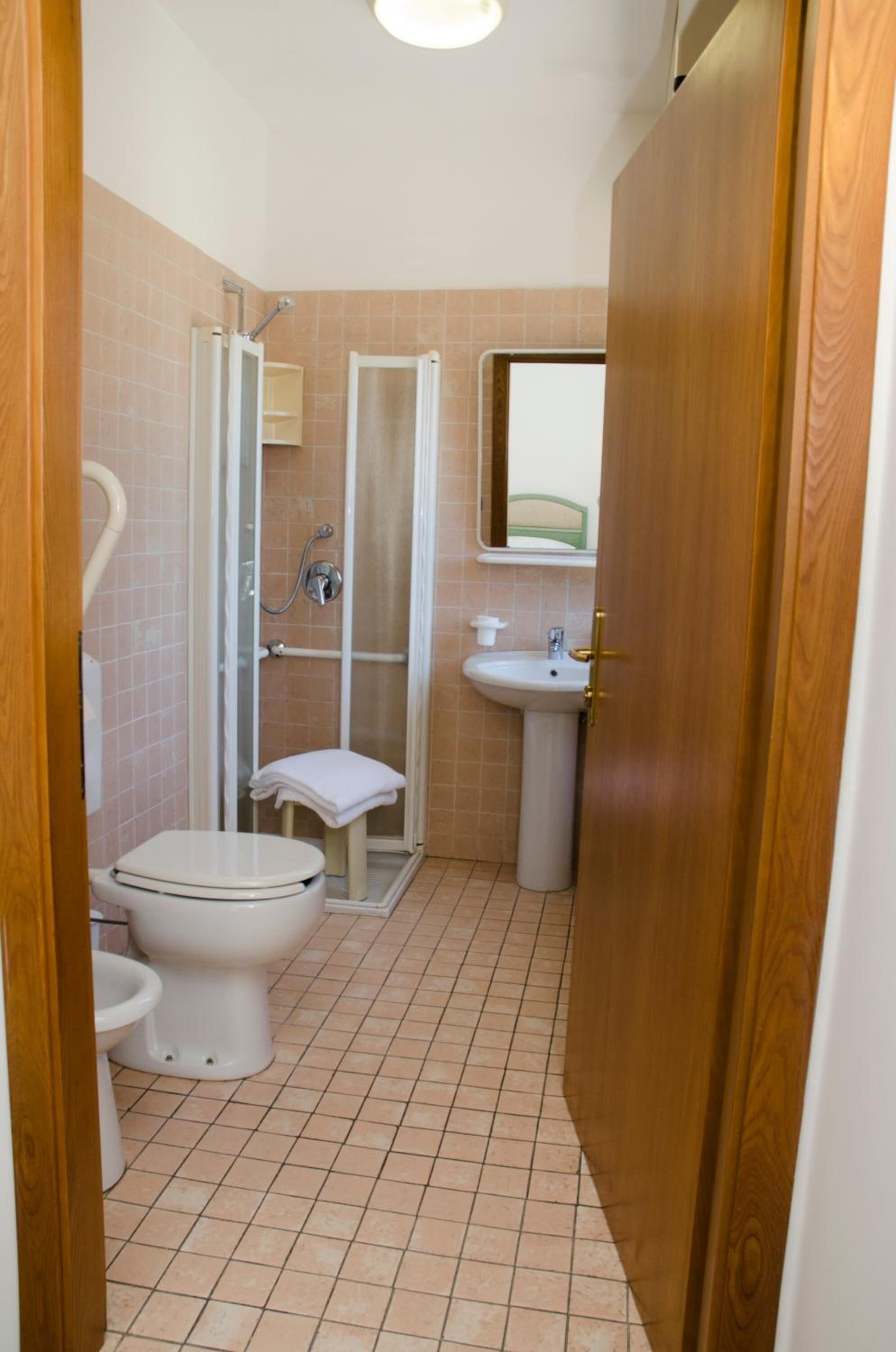 Un baño con inodoro, lavamanos y cabina de ducha.