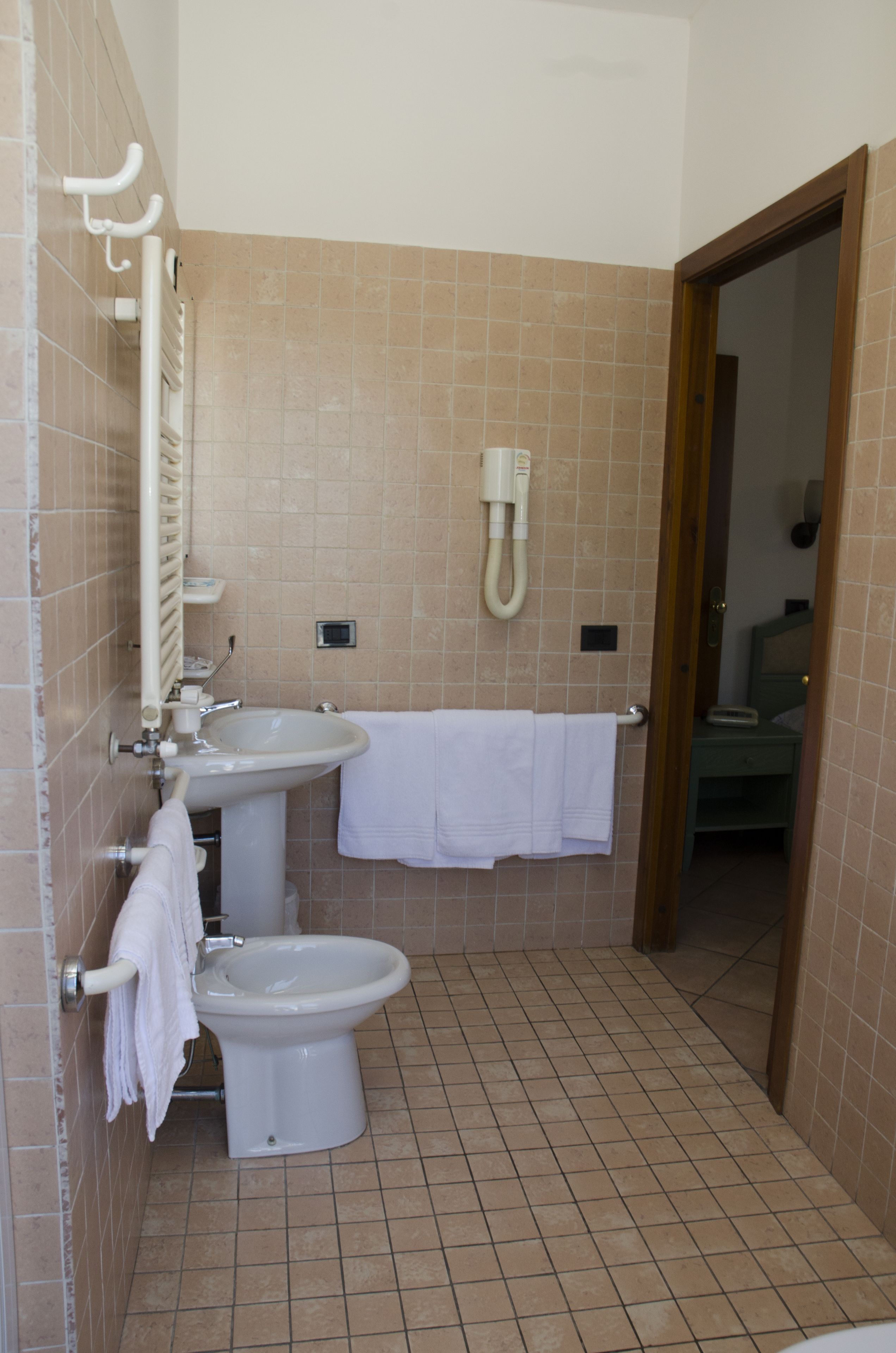 Een badkamer met toilet, wastafel en handdoekrek.
