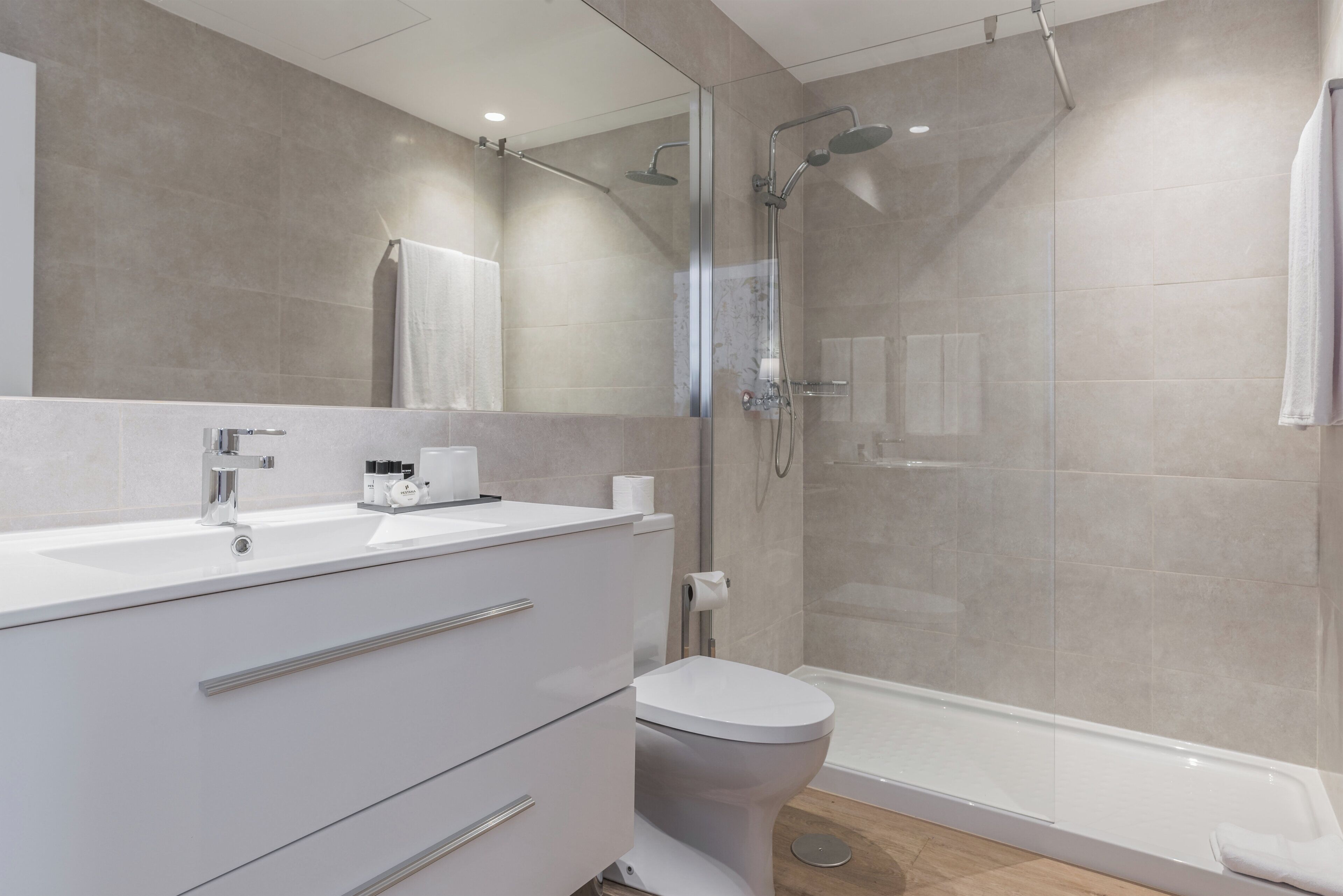 A modern bathroom with a shower, toilet, and vanity.