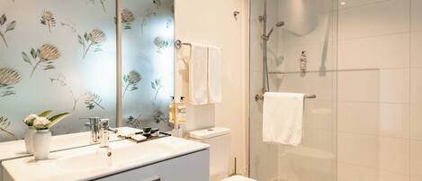 Un baño con ducha, inodoro y lavabo.