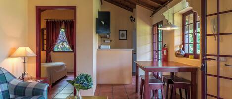 A cozy room with a sofa, a dining table, and a kitchen area.