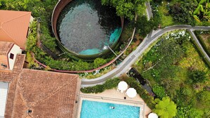 An aerial view of a resort with a swimming pool, lounge area, and surrounding greenery. - Pestana Quinta do Arco Nature & Rose Garden Hotel (Santana)