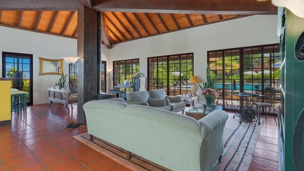 A spacious living area with a high ceiling, large windows, and a view of the outdoors. - Pestana Quinta do Arco Nature & Rose Garden Hotel (Santana)