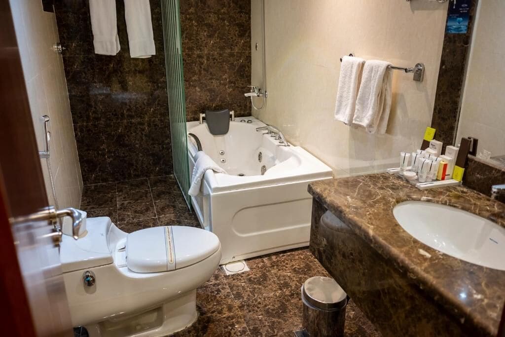 Ein Badezimmer mit Toilette, Badewanne und zwei Waschbecken.