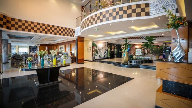 A spacious lobby with a checkered floor pattern, a central reception desk, and a second-floor balcony with decorative railings. - Meral Crown Hotel (Riyadh)
