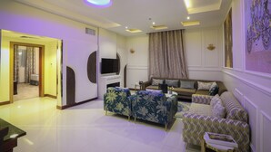 A modern living room with a sofa, armchairs, and a flat-screen TV. - Meral Crown Hotel (Riyadh)