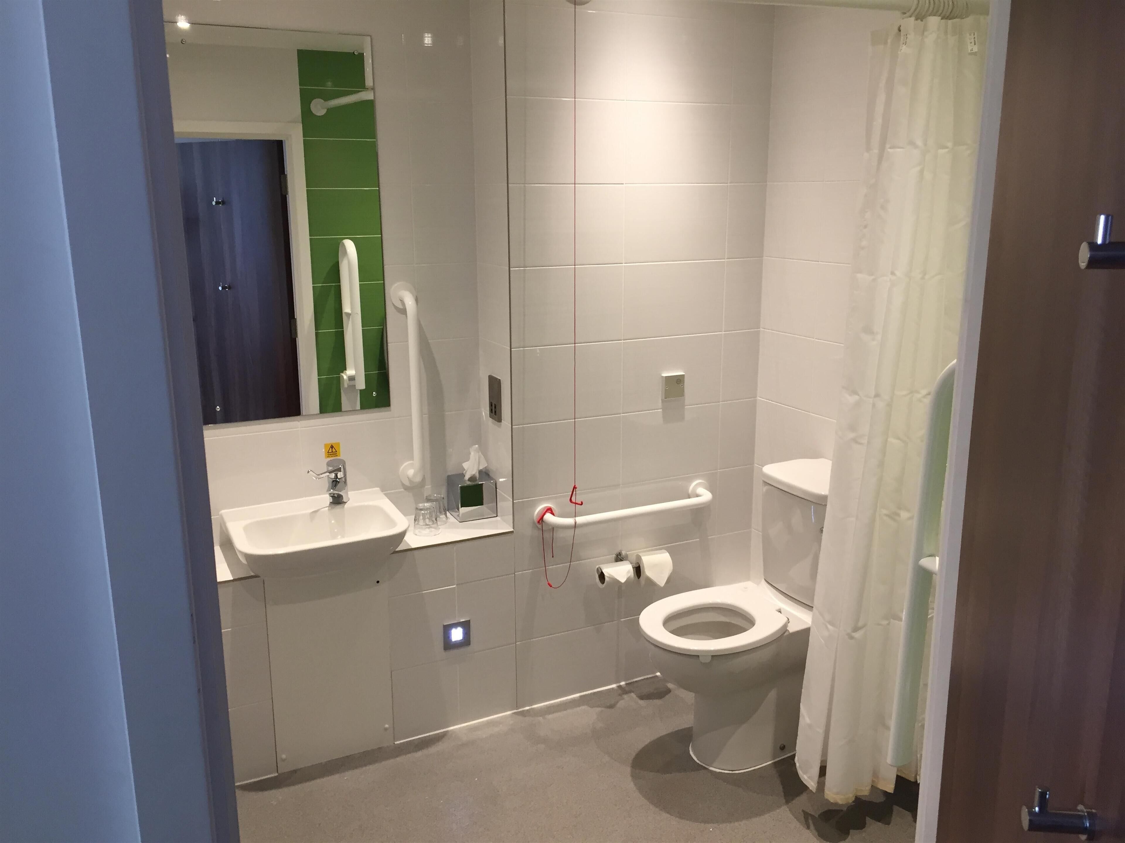 Un baño moderno con lavabo, inodoro y zona de ducha.