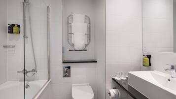 A modern bathroom with a glass-enclosed shower, a toilet, and a sink with a mirror.