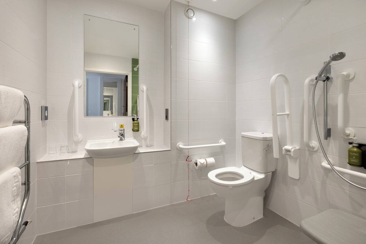 A modern bathroom with a toilet, sink, and shower.