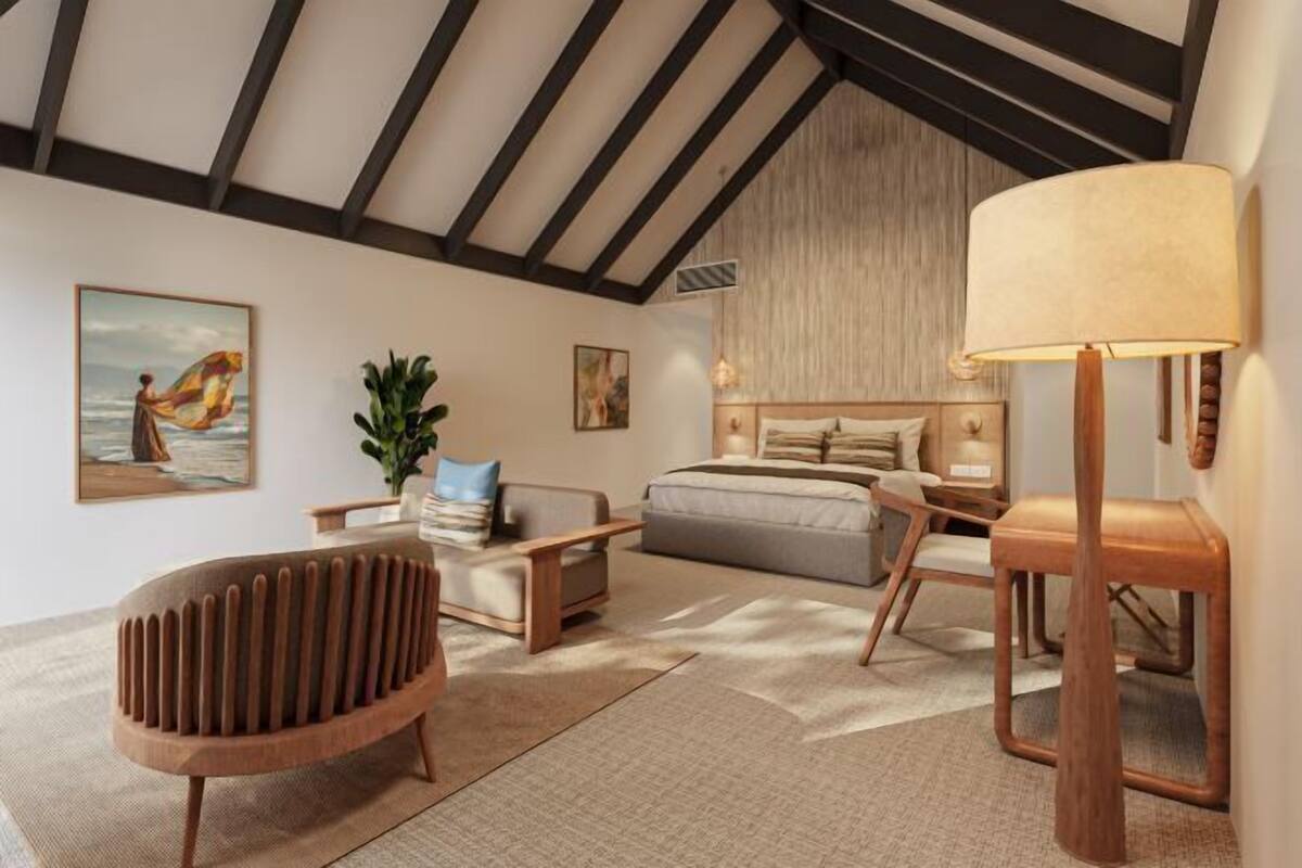 Ein modernes Schlafzimmer mit schrägen Wänden, einem Bett, einem Nachttisch, einer Lampe und einem Sessel.